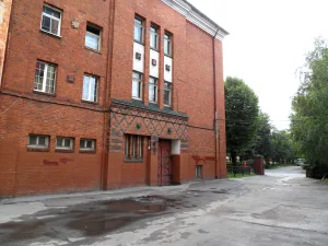 Здание Хуфенского лицея с головами двух девушек над входом